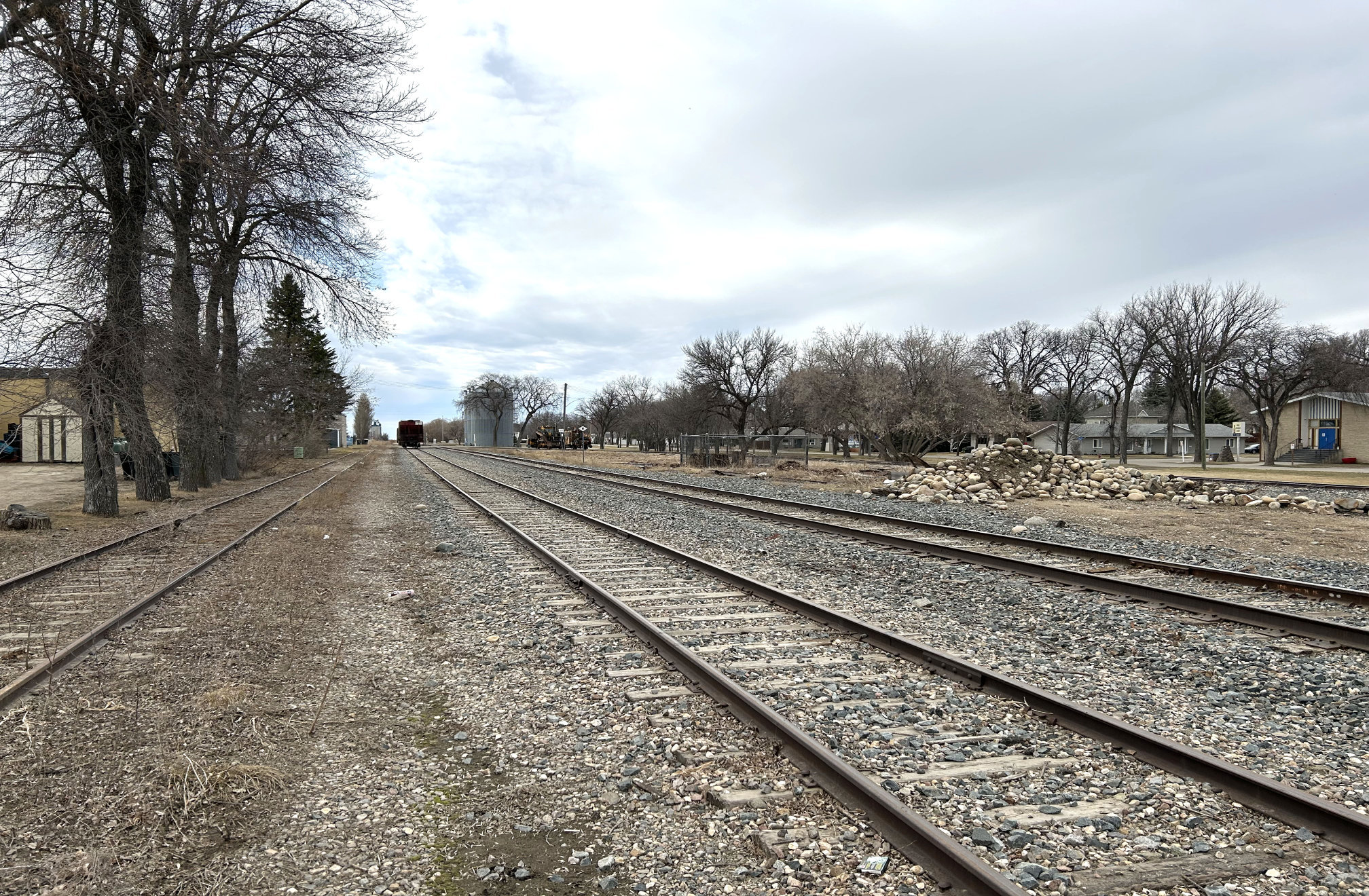 [2024 photo of former railroad station site looking west along the tracks from Broadway]