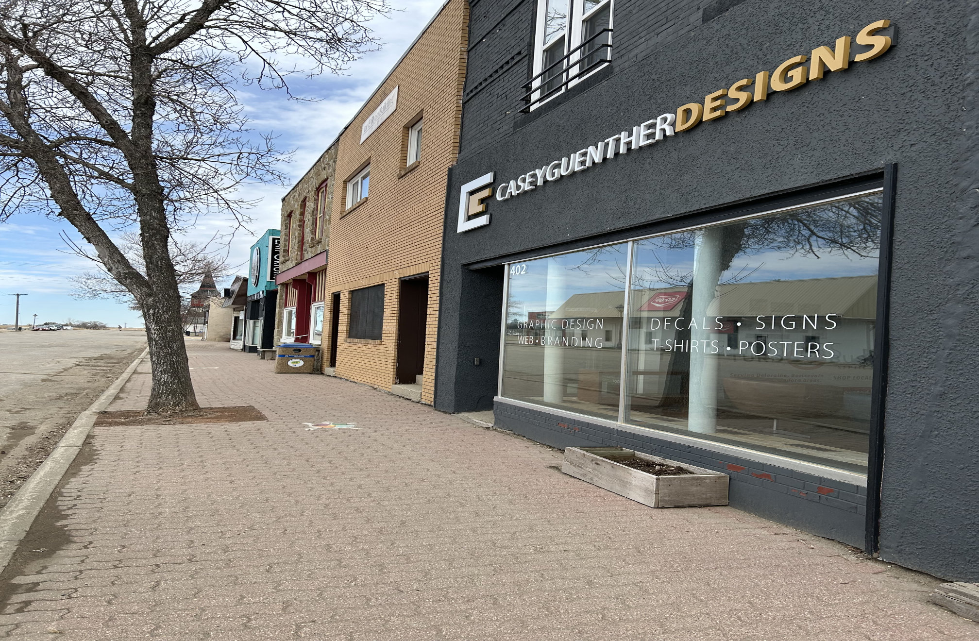 [2024 photo of South Railway building fronts looking east from Casey Guenther Designs (#402)]